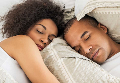 An African American couple sleeping without suffering from tinnitus