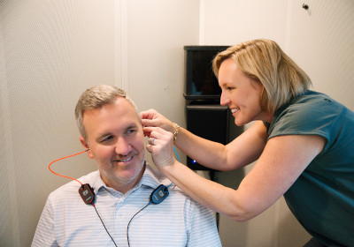 Megan Kelly, MS assisting a patient during a hearing test