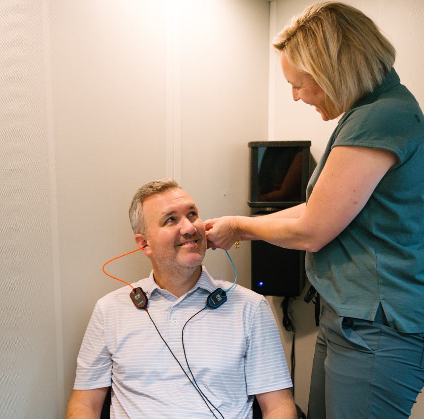 Megan Kelly fitting hearing aid on patient